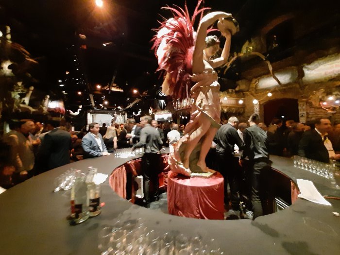 Intérieur du musée des arts forains rempli de personnes principalement masculines et en costume